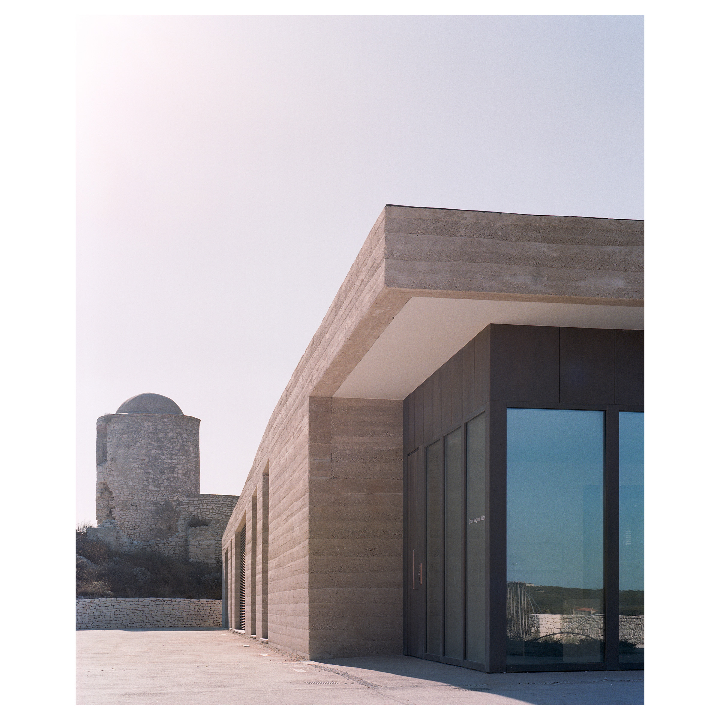 Photographie argentique de de la crèche Montlaur à Bonifacio en Corse, construit par l'agence d'architecture Buzzo Spinelli. Parvis d'entrée et relation à la tour bordant le bâtiment © Guillaume Porche