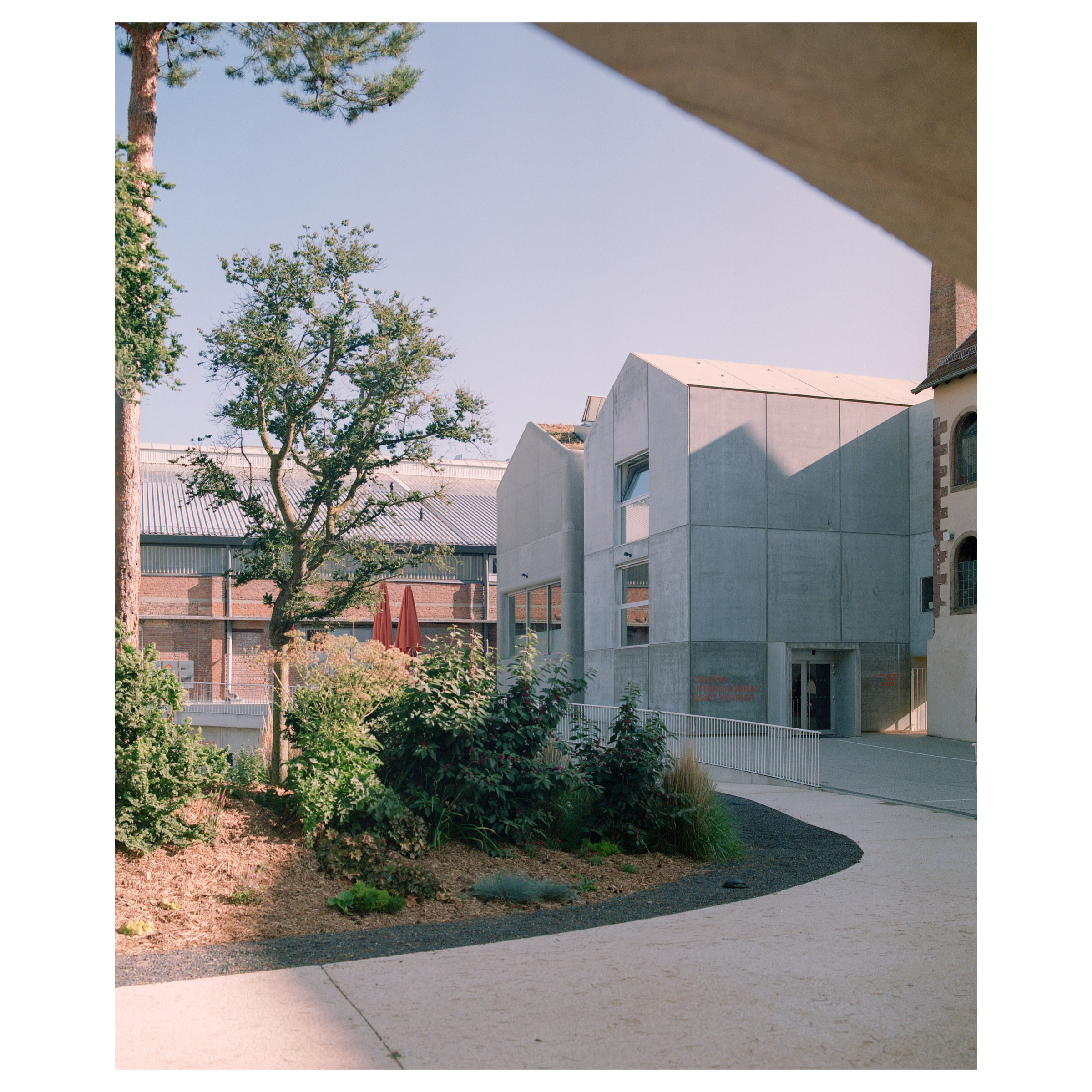 Photographie argentique du site verrier de Meisenthal (France) construit par les agences d'architectures SO-IL et Freaks. Les deux bâtiments de béton © Guillaume Porche